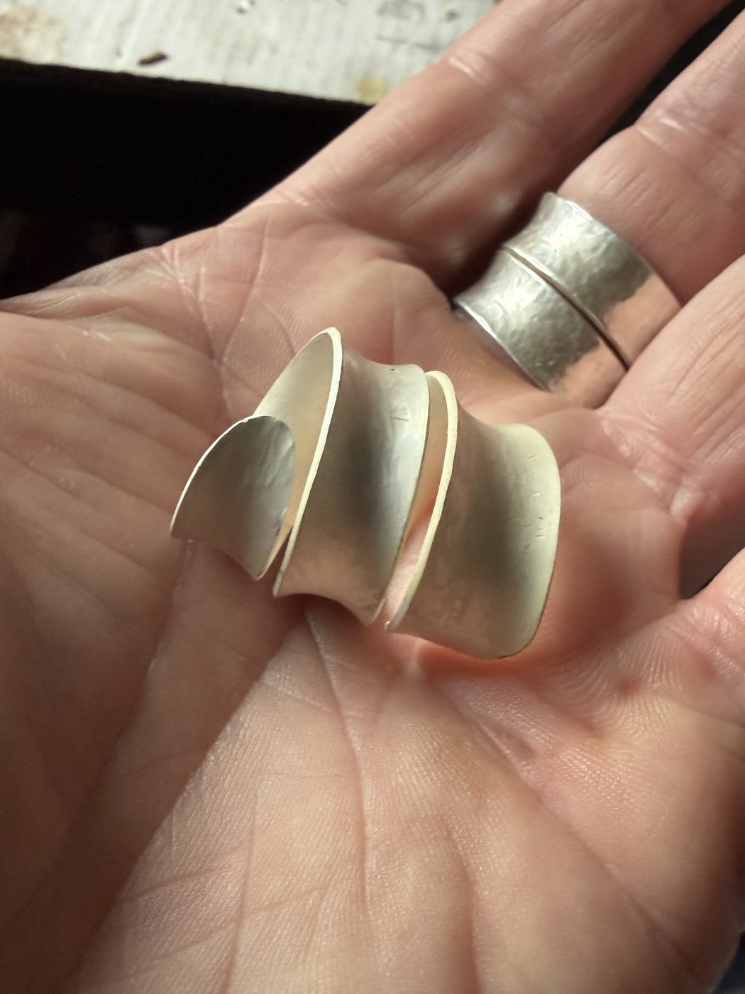 Anticlastic wrap ring held in an open palm