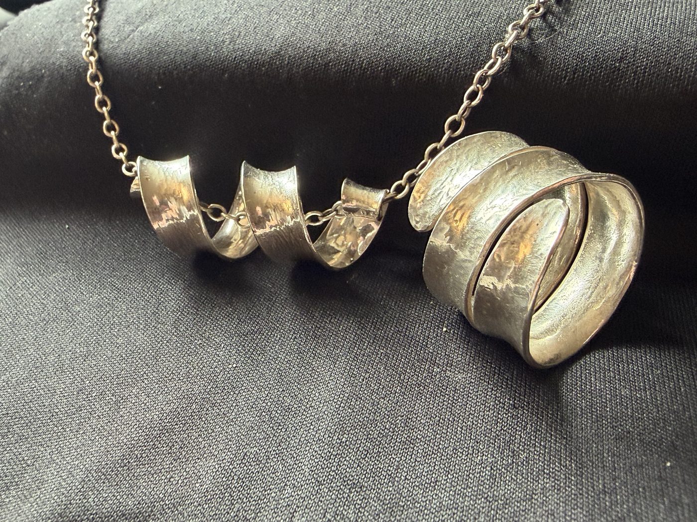 Spiral pendant and wrap ring together on black cloth